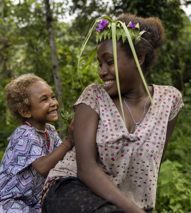 Lucy, four, playing with Joyce, 13, in a remote community in Malaita Province, the Solomon Islands