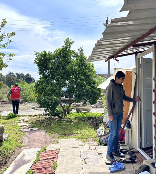 A teenager stands in front of a shelter following an earthquake.