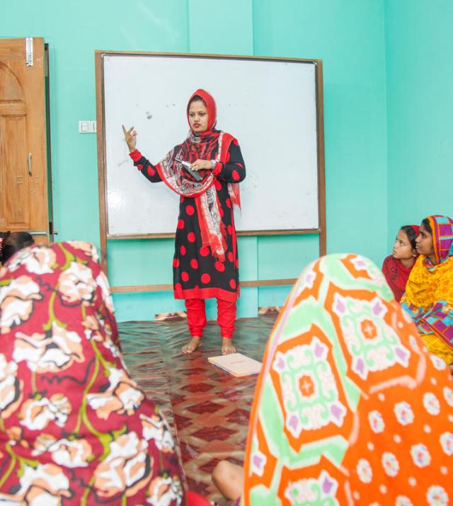 Photo of a woman speaking to a group of women