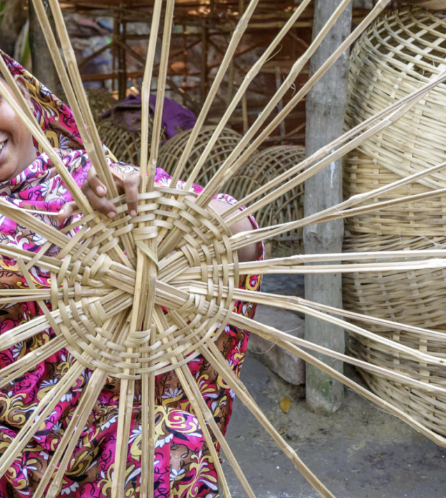 Images shows a young woman weaving a basket as a part of Nobo Jatra World Vision Bangladesh's graduation program