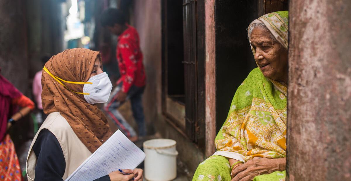 Community health worker speaks with a woman in Mumbai