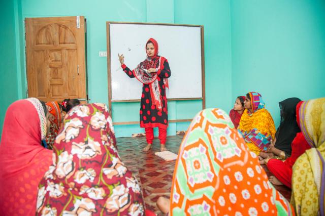 Photo of a woman speaking to a group of women