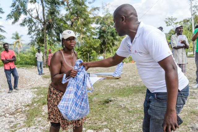 A man gives materials to a woman