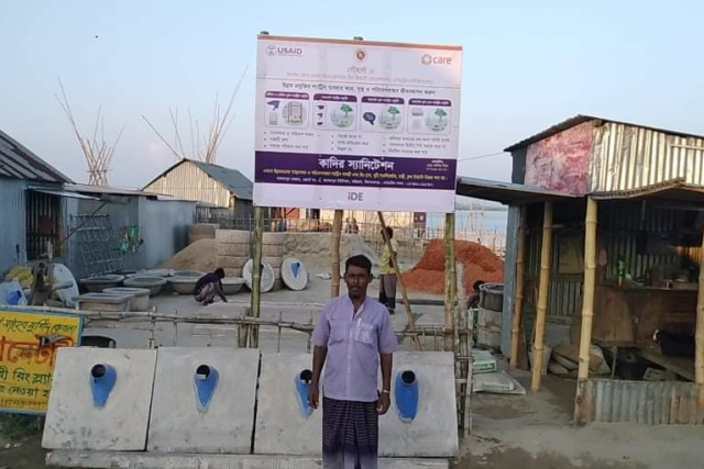A man is standing in front of latrines