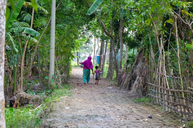 Mom and daughter carry water back to their home